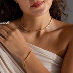 A woman wearing a Diamond Bezel Tennis Necklace & Bracelet Set, dressed in a cream-colored, off-shoulder top.