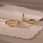 Art Deco Diamond Earrings & Ring Set, featuring a gold ring and two gold earrings with small diamonds, evocative of vintage glamour, displayed on textured white paper.