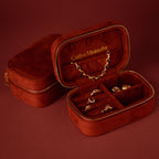 Open cherry red velvet jewelry case with gold rings, earrings, and necklace, labeled Caitlyn Minimalist—a perfect luxury jewelry storage solution.