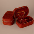 Two Cherry Red Velvet Jewelry Cases—one open to showcase gold jewelry, the other closed—ideal for luxury jewelry storage and elegant display.