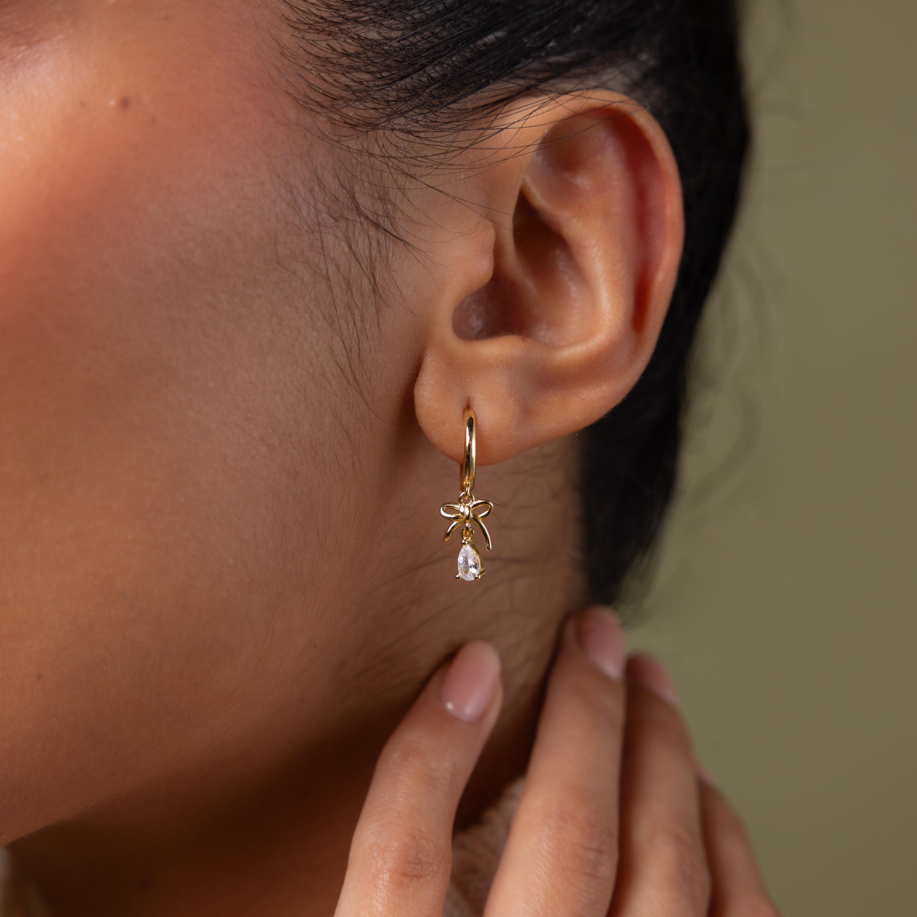 Close up of model wearing our Teardrop Ribbon Charm Hoops in Gold