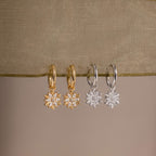 Two pairs of our Diamond Poinsettia Hoops hung on a green sheer ribbon