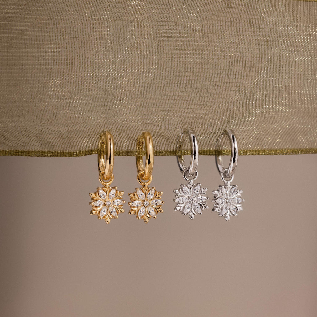 Flatlay of our Diamond Poinsettia Hoops in Silver and Gold