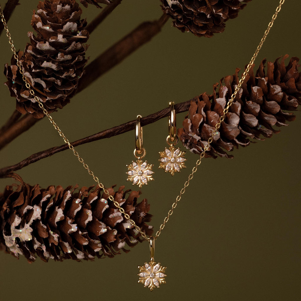 Flatlay of our Diamond Poinsettia Hoops paired with our Diamond Poinsettia Necklace
