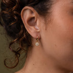 Close-up of a model wearing our Diamond Poinsettia Hoops