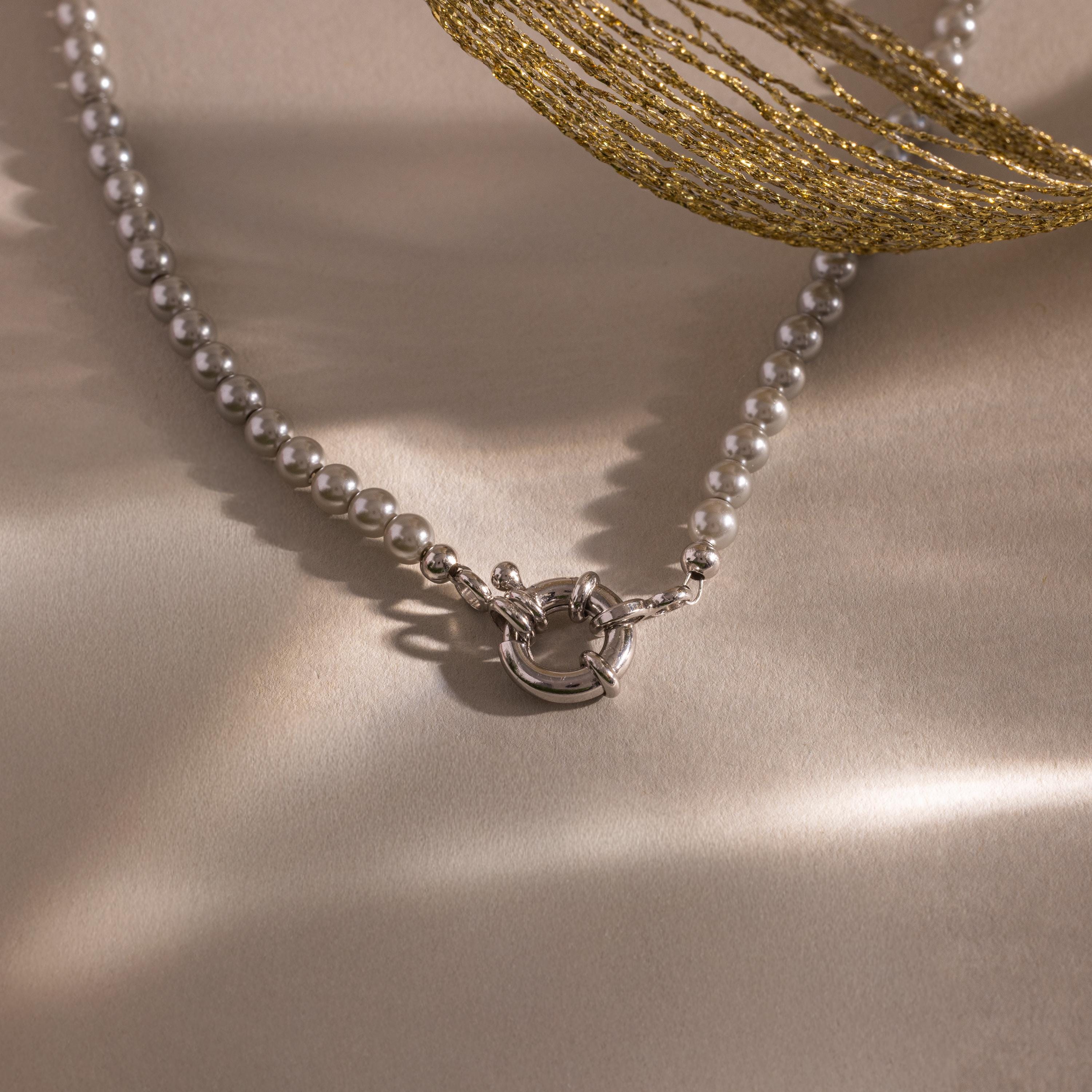 Flatlay of our Smoky Pearl Clasp Necklace on a beige background