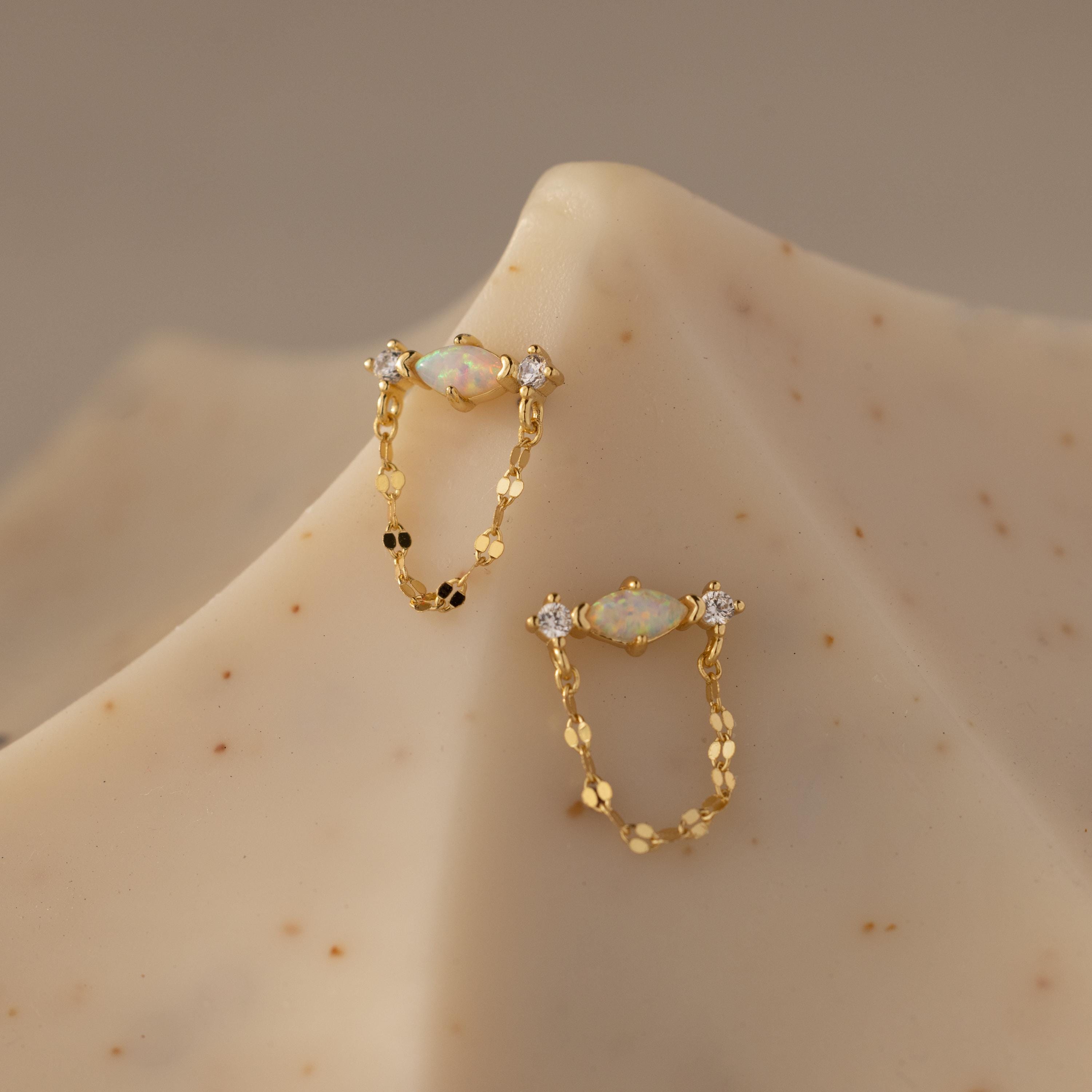 Flatlay of our Opal & Diamond Chain Studs on a beige surface