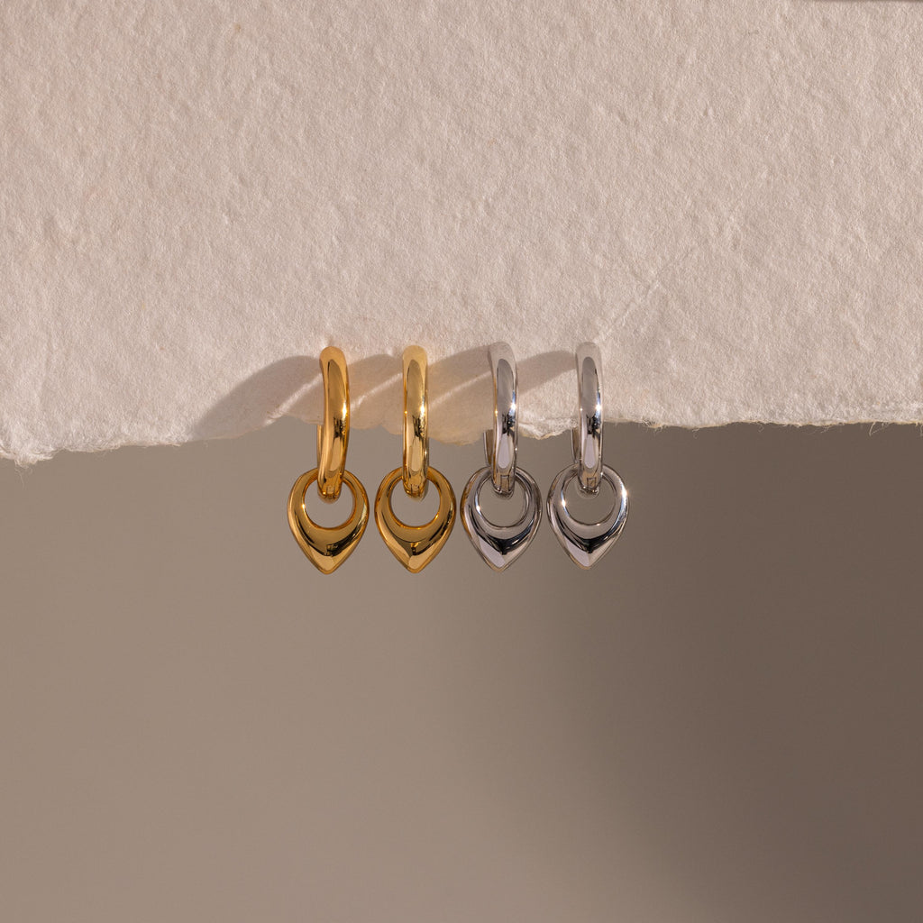 Flatlay of our our Tiny Teardrop Huggies in Gold and White Gold