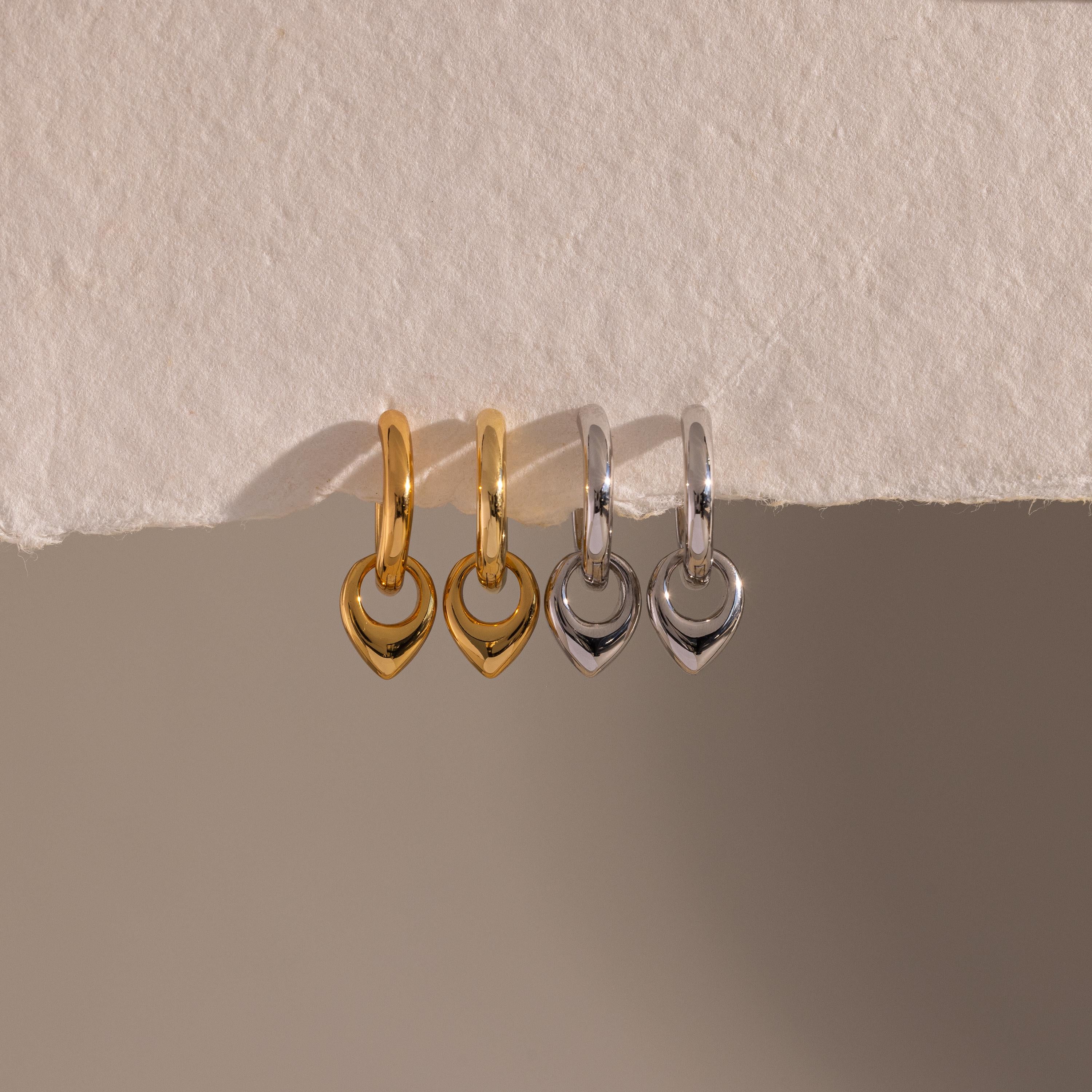 Flatlay of our our Tiny Teardrop Huggies in Gold and White Gold