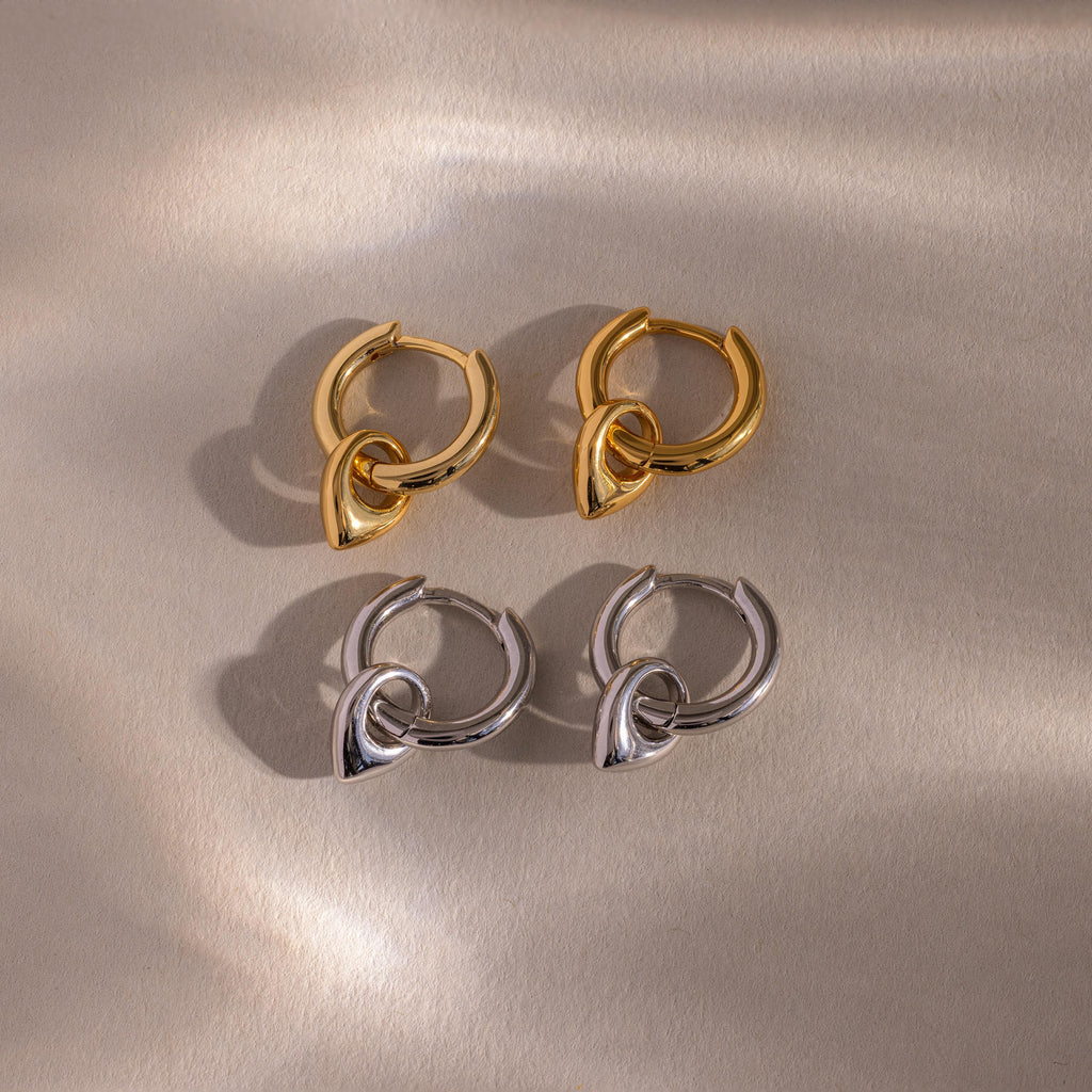 Close up flatlay of our Tiny Teardrop Huggies in Gold and White Gold