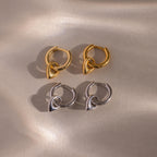 Close up flatlay of our Tiny Teardrop Huggies in Gold and White Gold