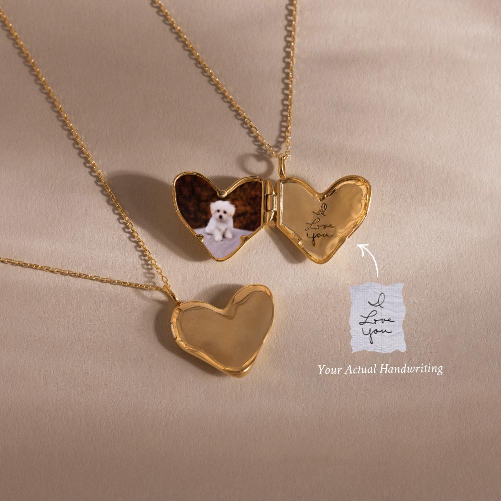 Two Organic Heart Locket Necklaces in 18K Gold—one open with a dog photo and an 'I love you' note, one closed—rest on a beige surface. A perfect keepsake for cherished memories.