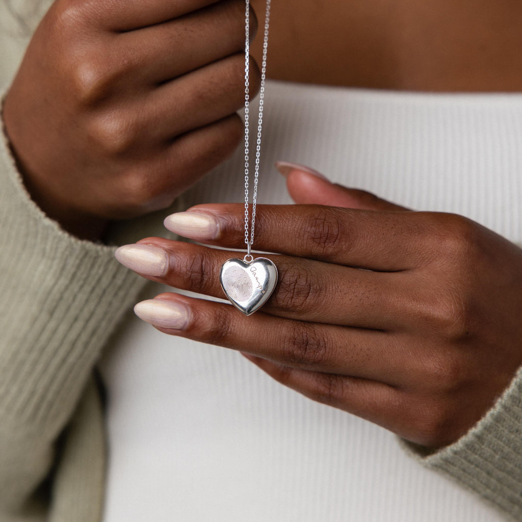 Model holding our Fingerprint Heart Locket Necklace in Sterling Silver
