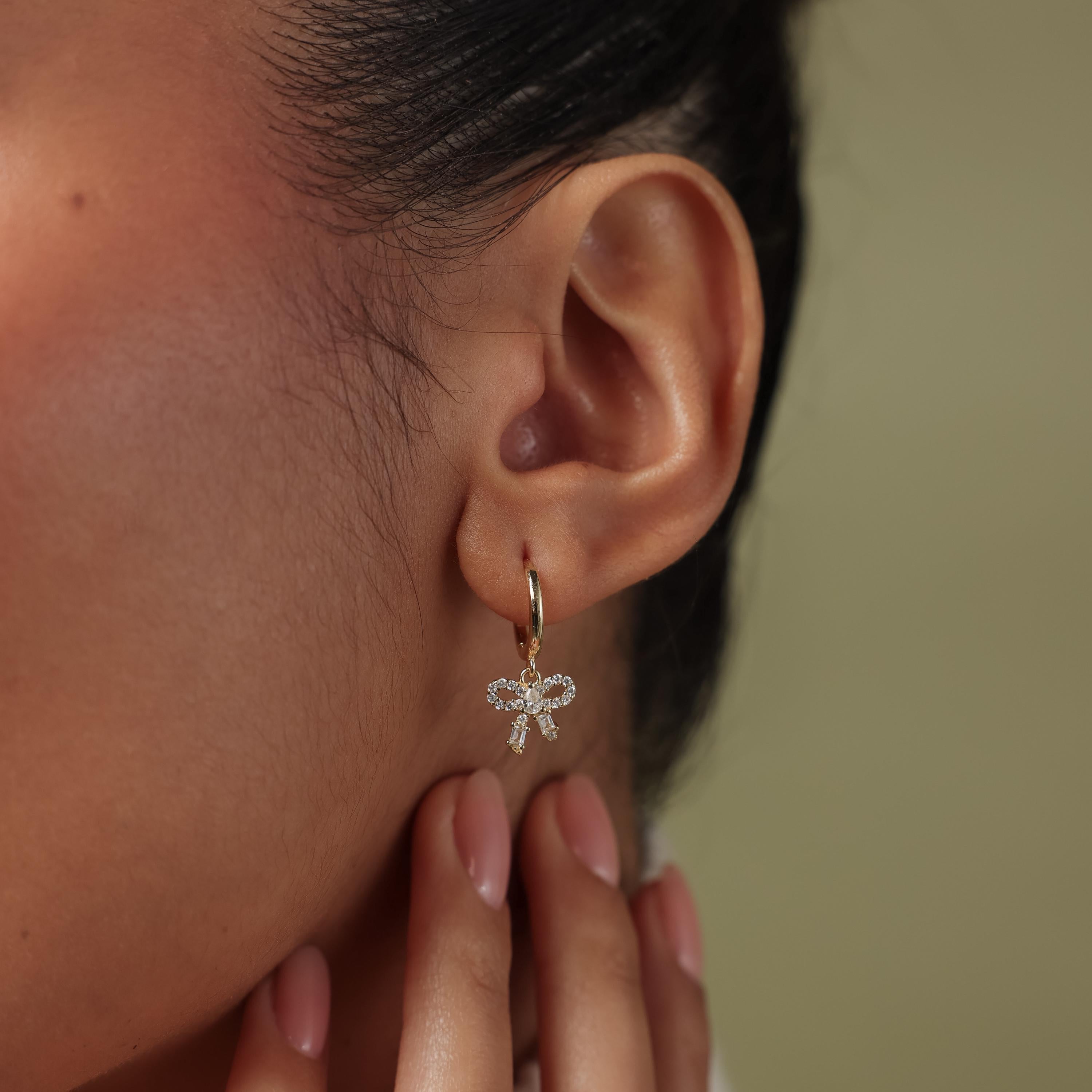 Close up of model wearing our Pave Bow Charm Hoops in Gold