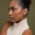 Woman wearing our Pave Bow Charm Hoops in Silver against a neutral background