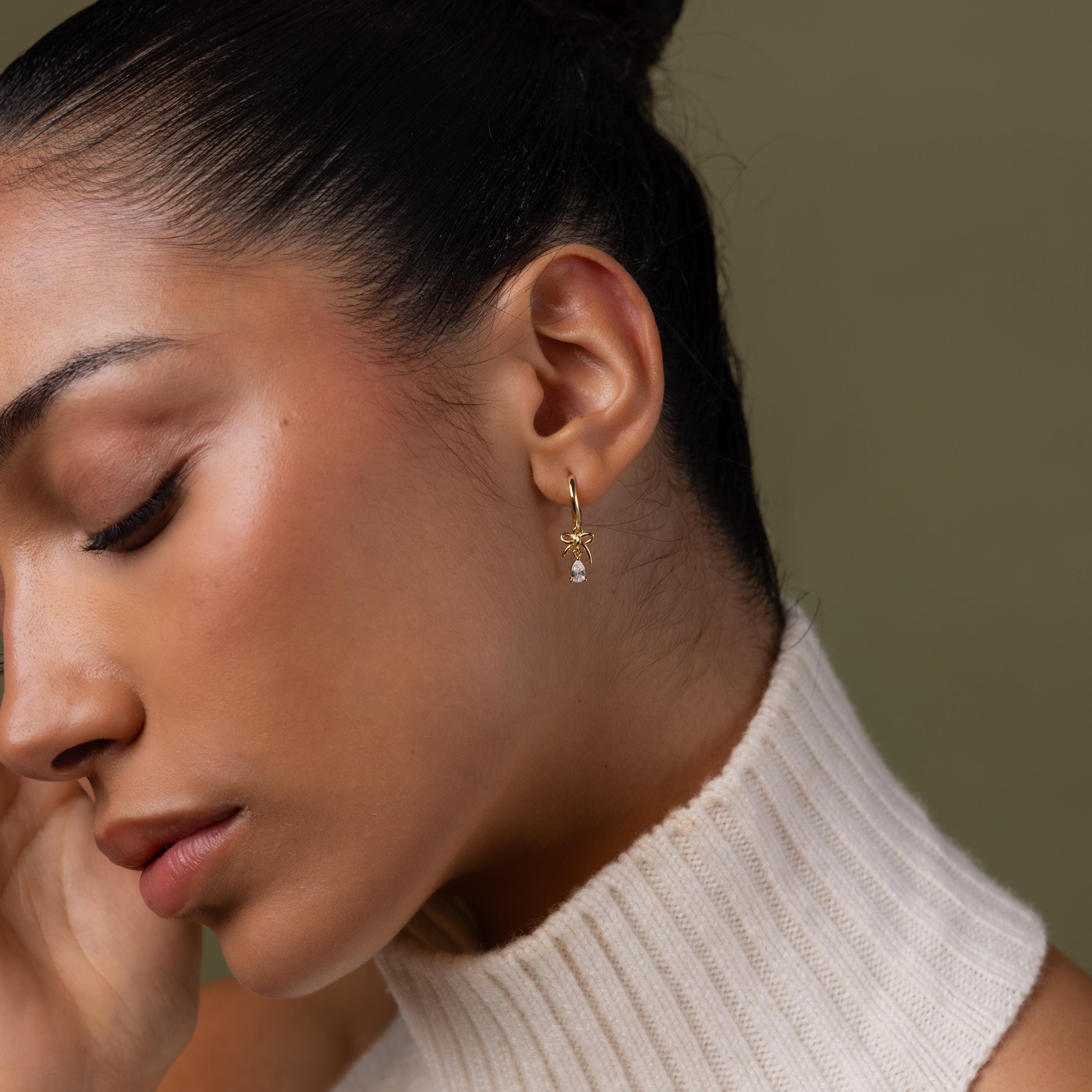 Model wearing our Teardrop Ribbon Charm Hoops in Gold