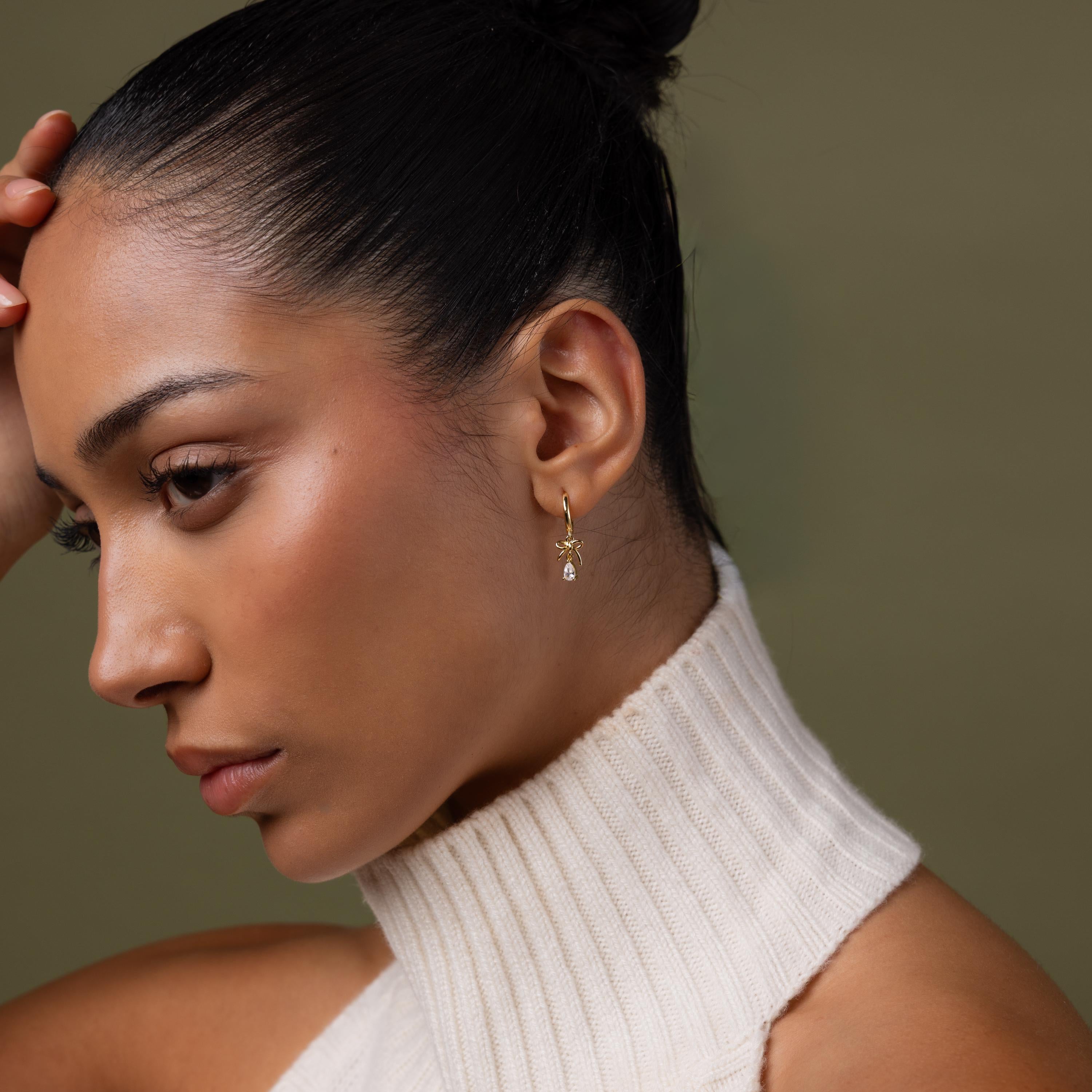 Model wearing our Teardrop Ribbon Charm Hoops in Gold
