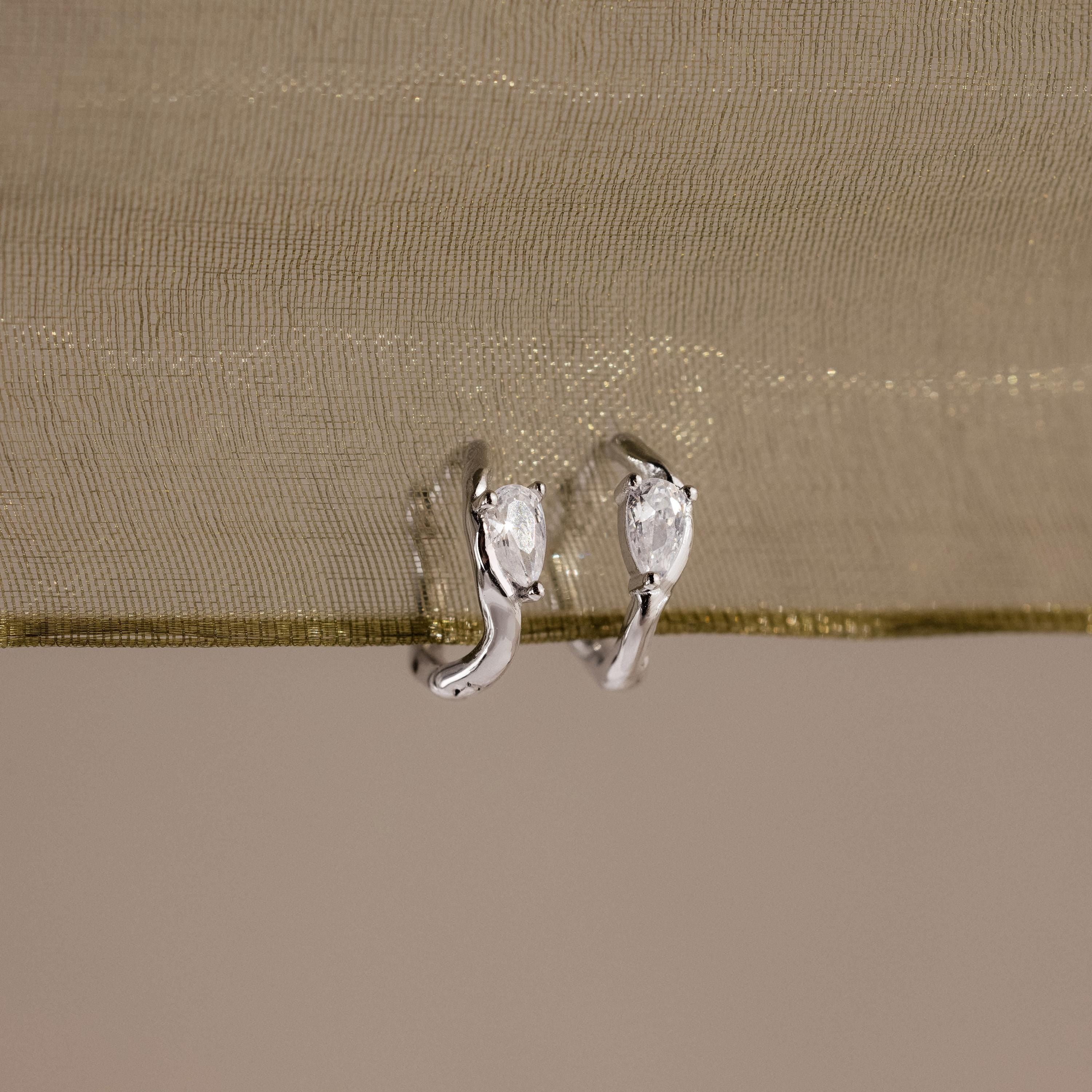 Flatlay of our Hammered Diamond Teardrop Hoops in Silver