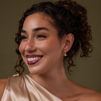 Model wearing our Holiday Tree Studs earrings against a green background