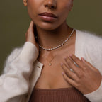 Model wearing our Diamond Poinsettia Necklace in Gold, styled with a pearl necklace