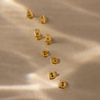 Flatlay of our Bubble Initial Flatback Studs in Gold, showcasing letters A, B, C & D
