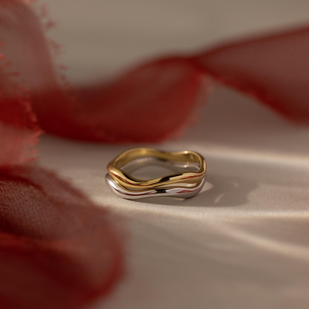 Flatlay of our Mixed Metal Wave Ring Set against red ribbons