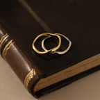 Flatlay of our Mixed Metal Wave Ring Set on a brown leather book