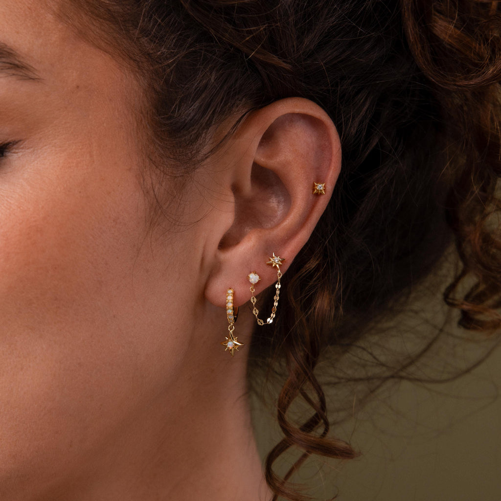 Close-up of a model wearing our Opal & Star Duo Chain Studs, styled with our North Star Flatback Studs and Pave Opal Star Huggies