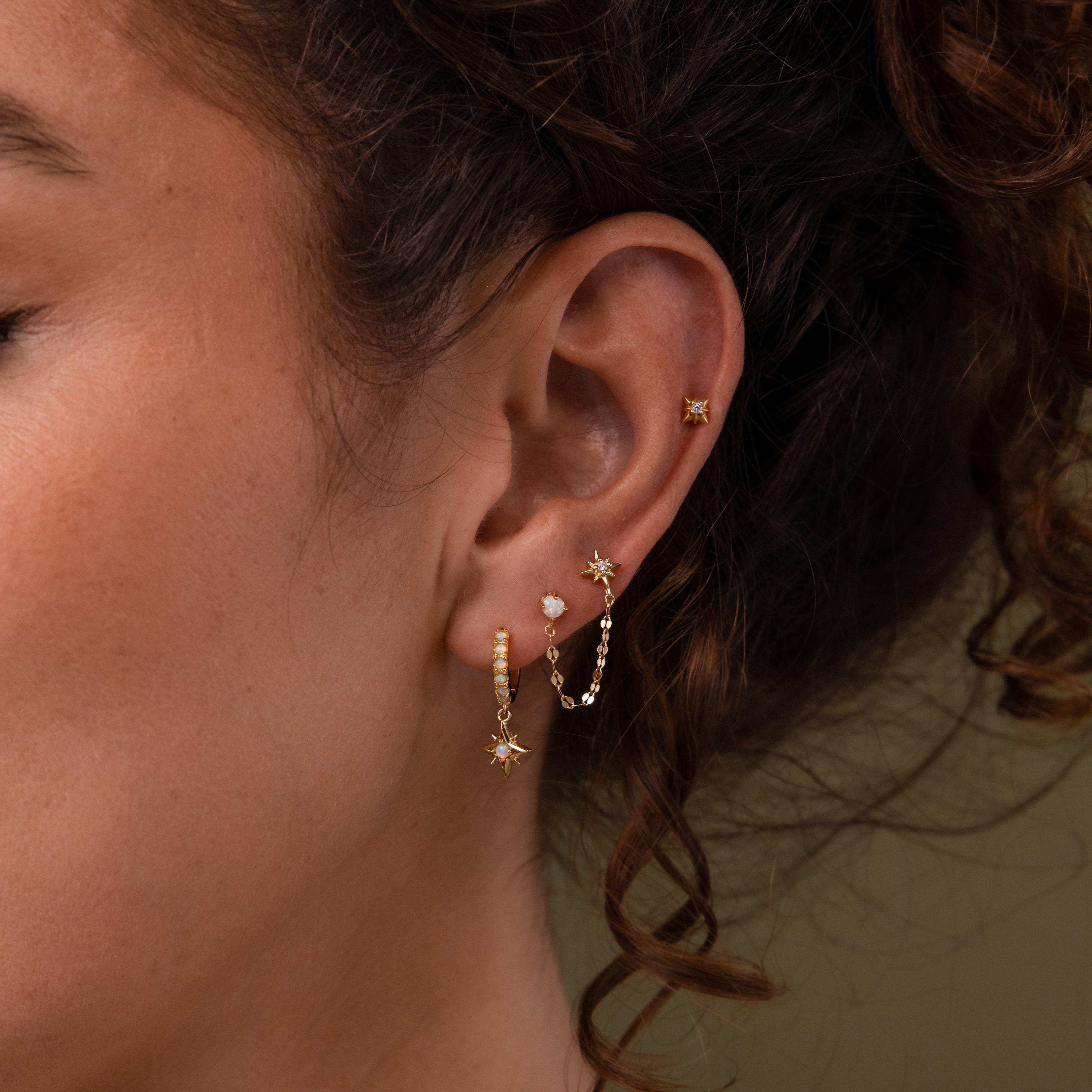 Close-up of a model wearing our Opal & Star Duo Chain Studs, styled with our North Star Flatback Studs and Pave Opal Star Huggies