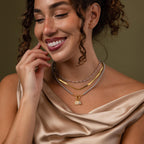 Faraway shot of a model wearing our Smoky Pearl Clasp Necklace with our Eternity Pearl Necklace and Herringbone Necklace