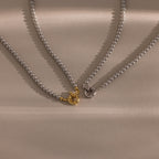 Flatlay of our Smoky Pearl Clasp Necklace in Gold and White Gold