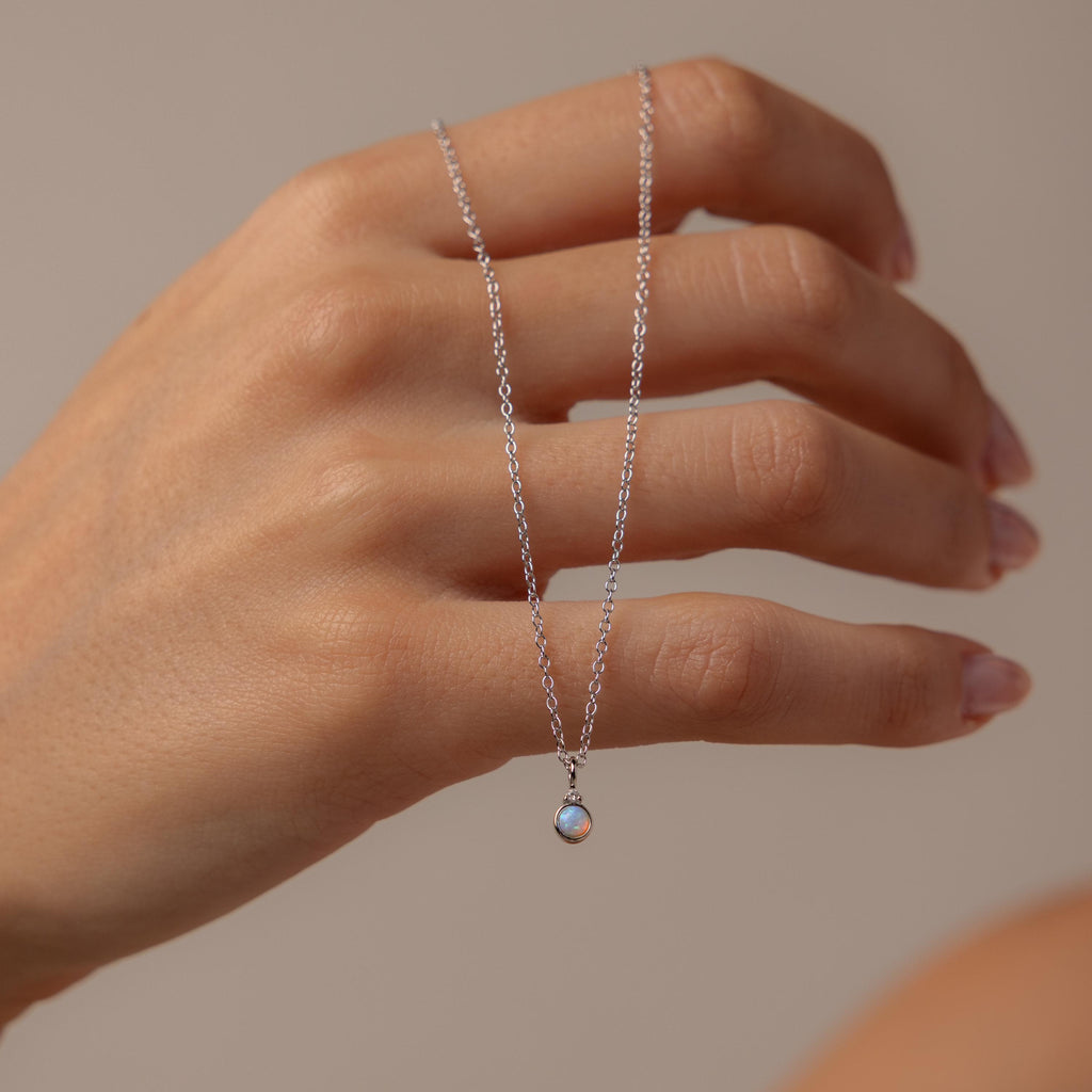 Model holding our Opal Diamond Necklace in Sterling Silver