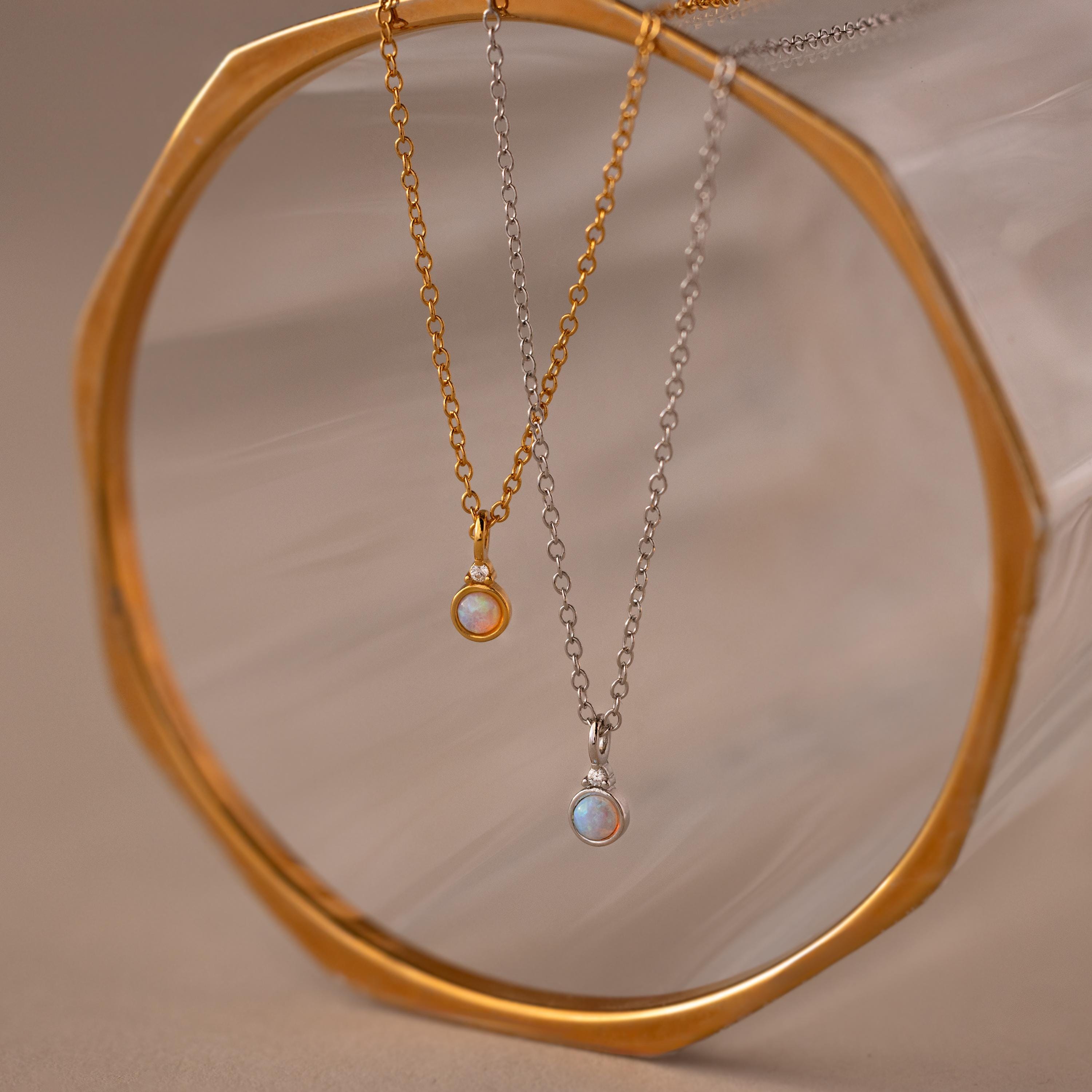 Flatlay of our Opal Diamond Necklace in Gold and Silver