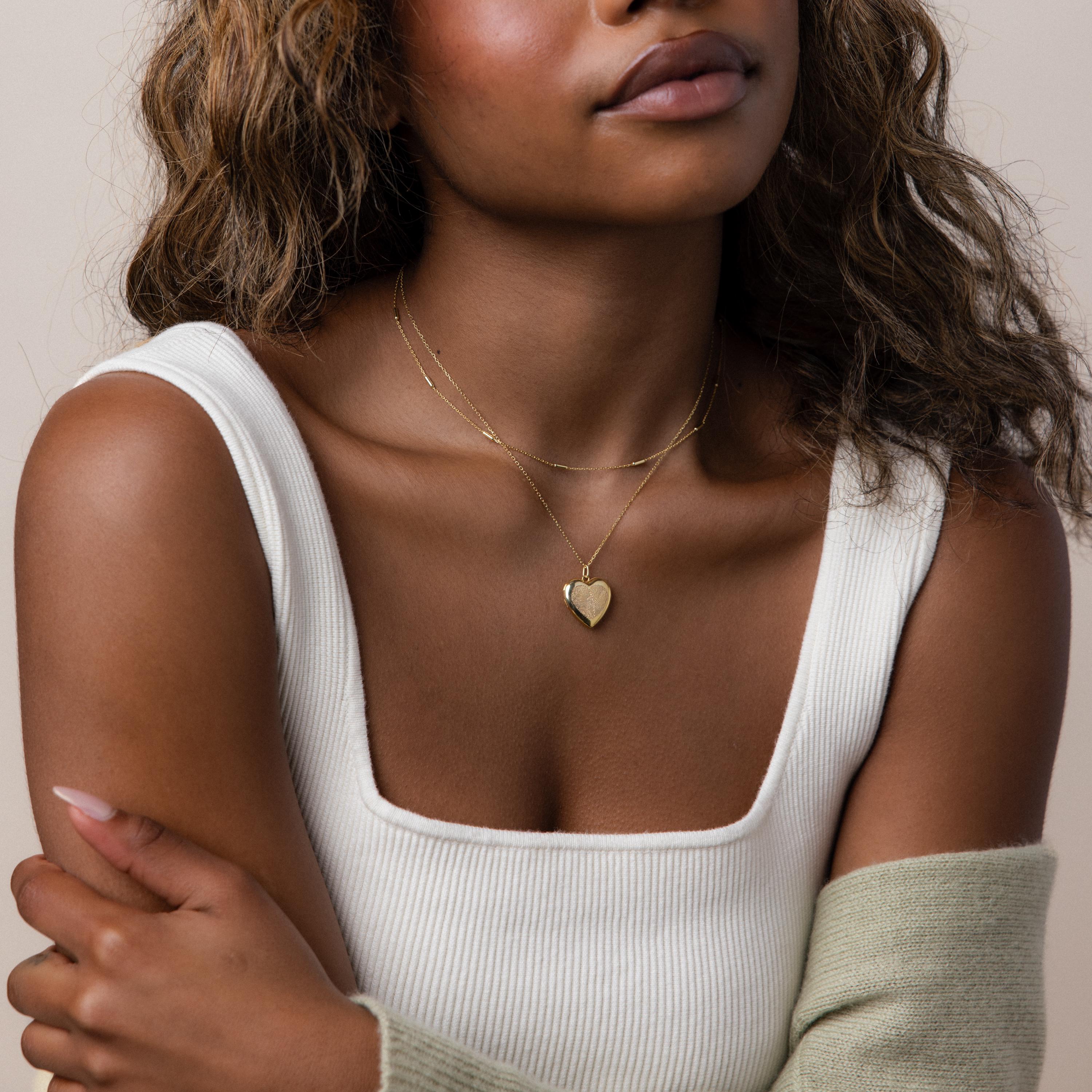 Model wearing our Fingerprint Heart Locket Necklace in Gold, styled with our Bar Station Necklace