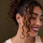 Faraway shot of a model wearing our Bubble Initial Flatback Studs