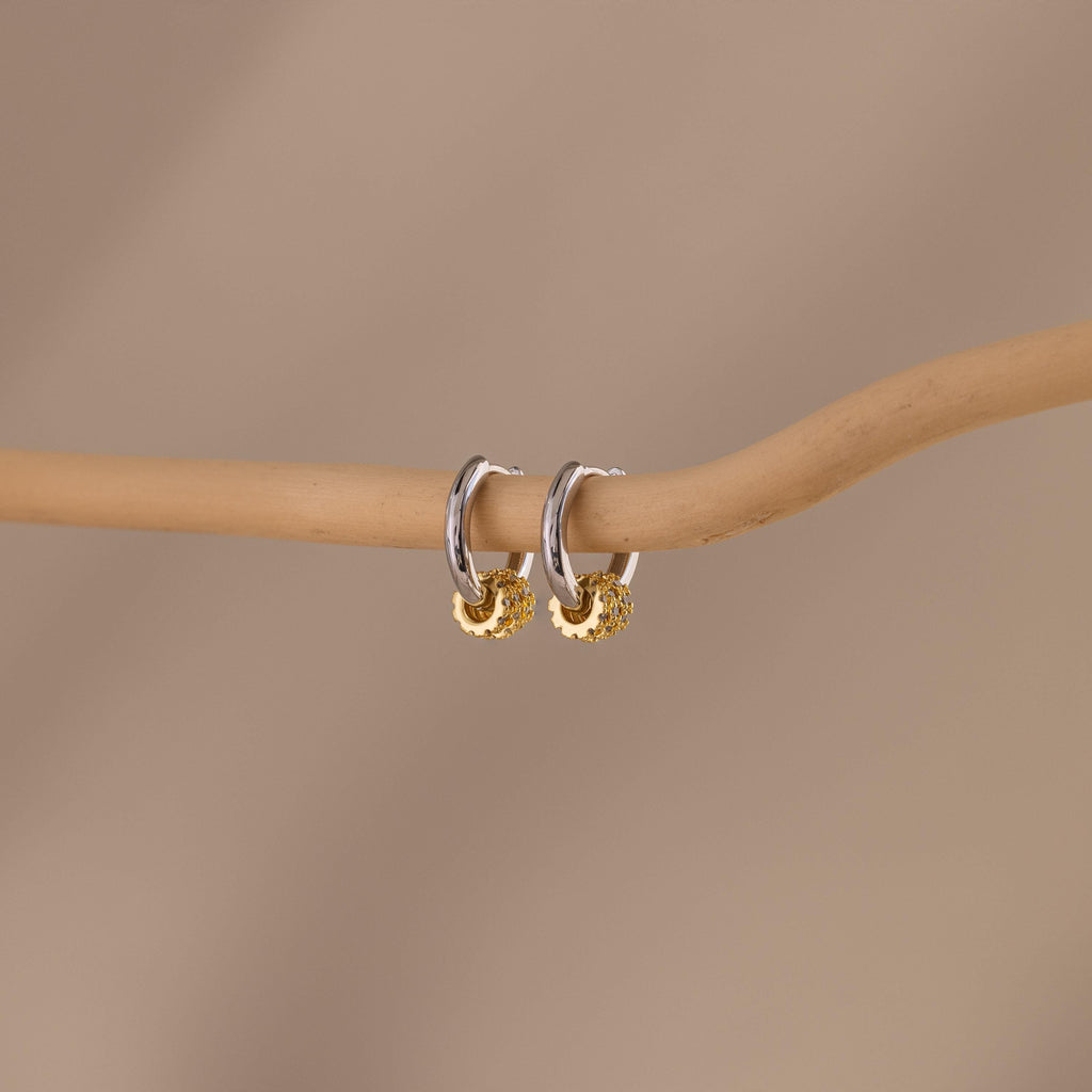 Our Mixed Metal Pave Hoops in White Gold hung on a wooden stick