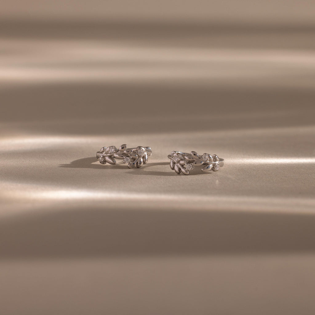 Flatlay of our Diamond Leaf Hoops in Sterling Silver