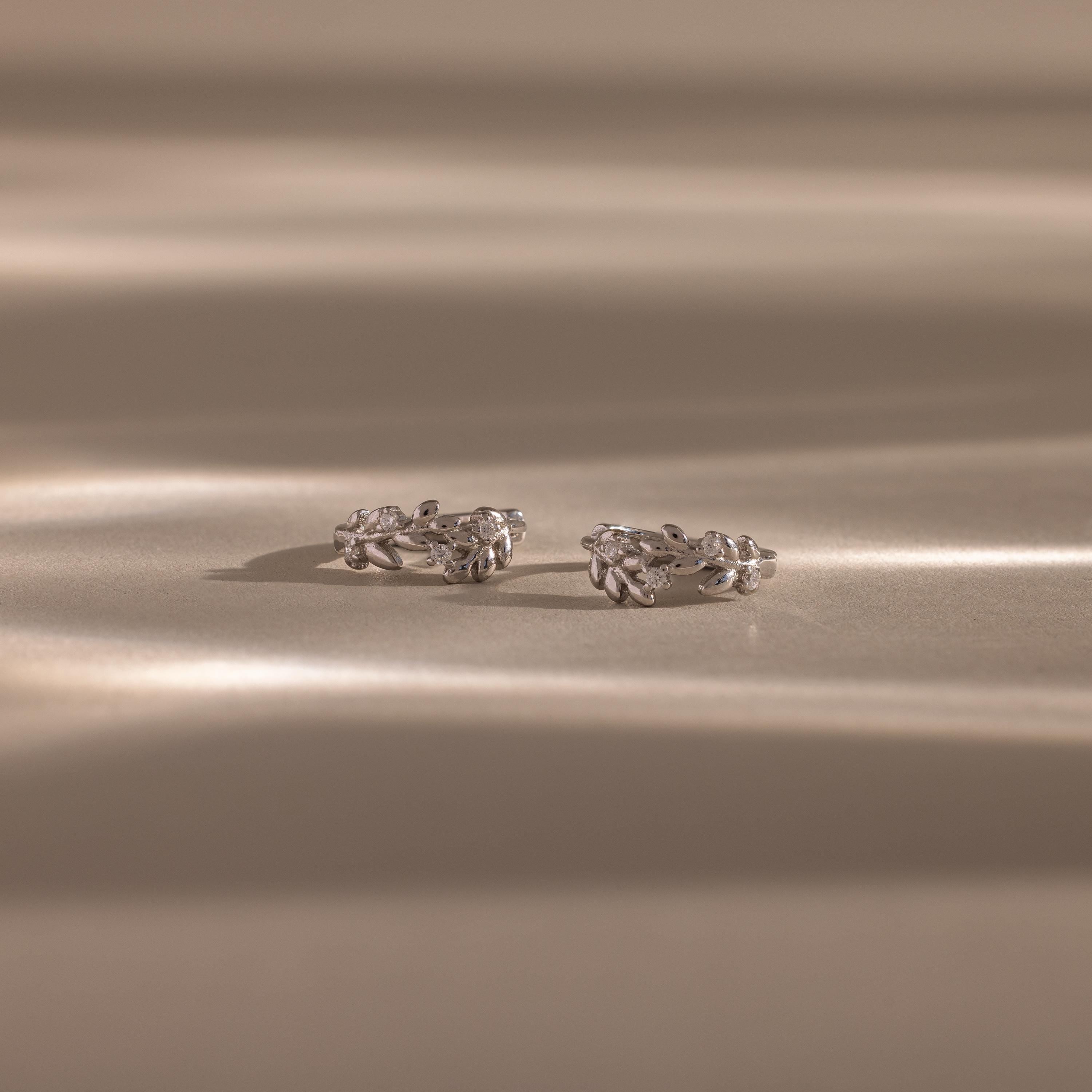 Flatlay of our Diamond Leaf Hoops in Sterling Silver