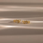 Close up flatlay image of our Diamond Leaf Hoops in 18K Gold