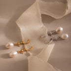 North Star Pearl Hoops featuring gold and silver star details are displayed on soft beige fabric.