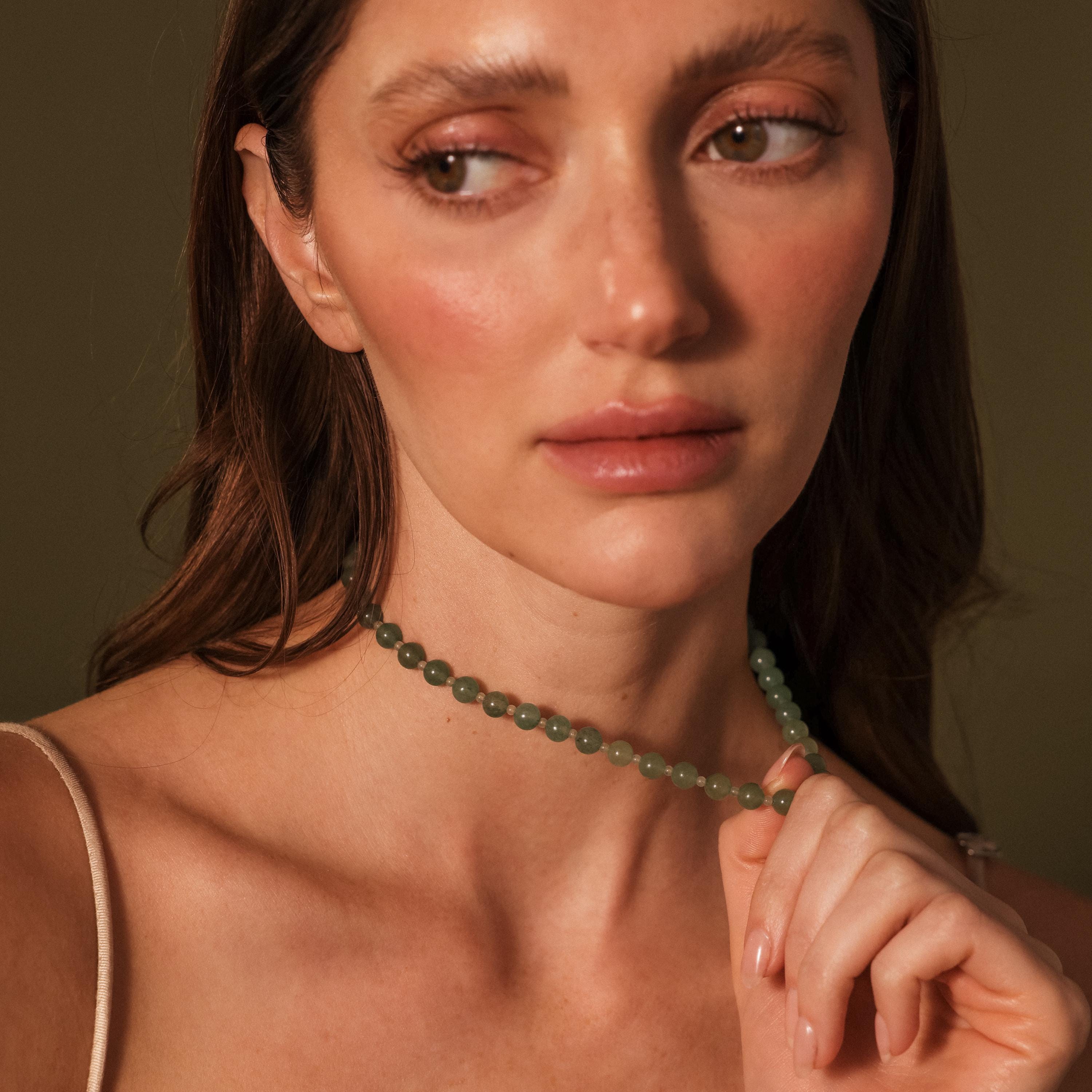 Woman with natural makeup wearing a stunning Jade Choker Necklace in Silver, looking off to the side.