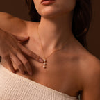 Woman wearing a strapless top and the Pearl Cascade Necklace in 18K Gold, featuring three elegant pearls—an ideal accessory for everyday elegance.