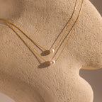 The Pearl Dot Necklace is displayed on a textured beige mannequin bust.