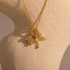 The Cable Circle Charm Necklace in 18K Gold features wing and heart statement charms, elegantly displayed on a textured beige sculpture bust.