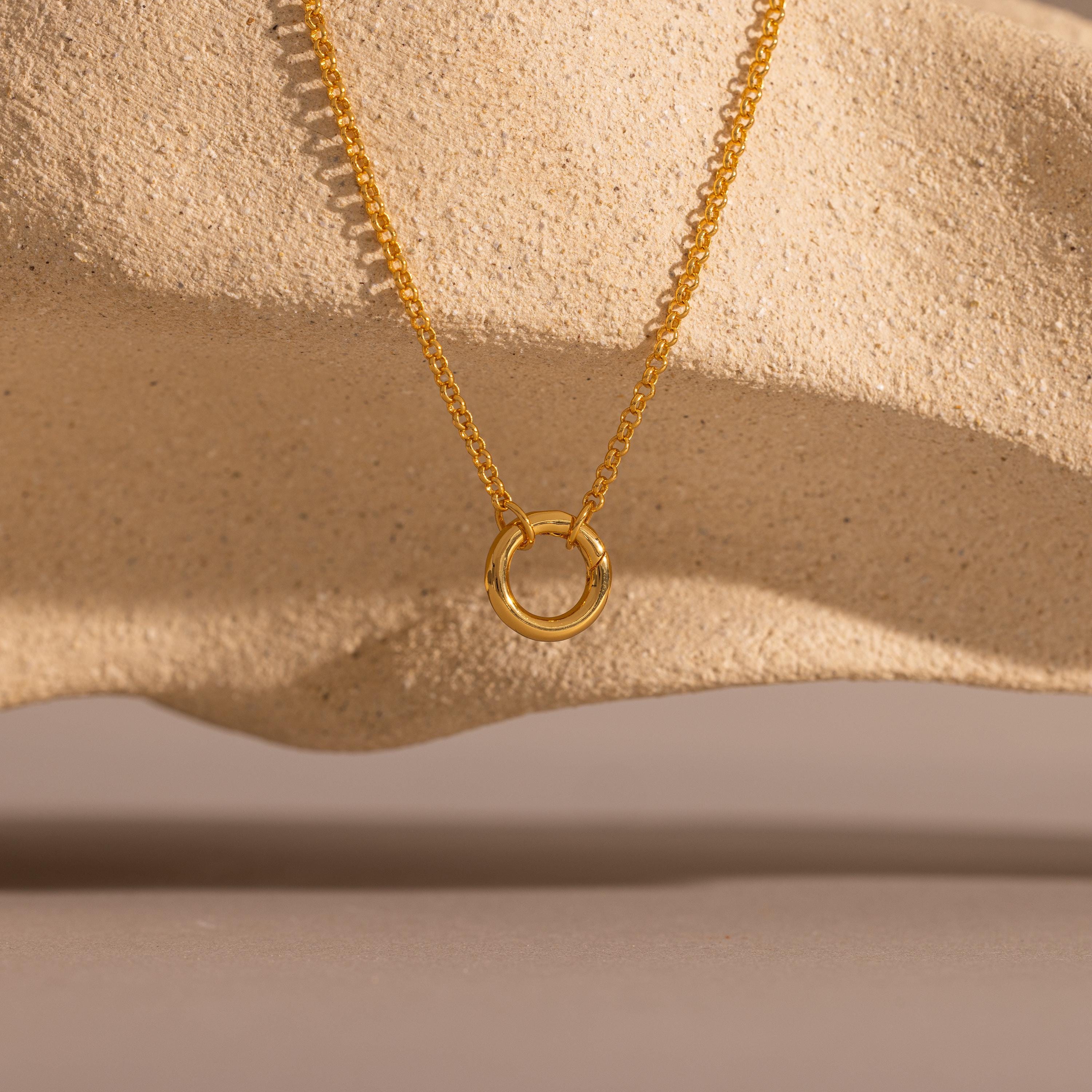 Cable Circle Charm Necklace shown on textured beige stone with soft shadows; a versatile piece ideal for layering and adding effortless elegance to any look.