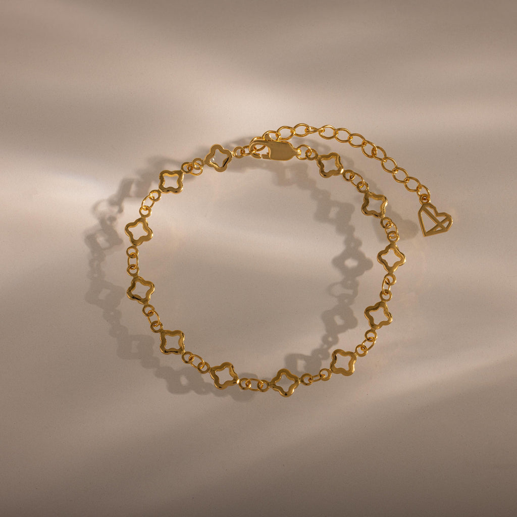 The Clover Station Bracelet features star-shaped links and an adjustable chain, styled on a neutral background with soft shadows for a beautiful, nature-inspired look.