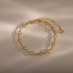 The Clover Station Bracelet features star-shaped links and an adjustable chain, styled on a neutral background with soft shadows for a beautiful, nature-inspired look.