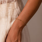 The Clover Station Bracelet adds a delicate, nature-inspired touch to your look—beautifully paired with a cream lace top and textured skirt.