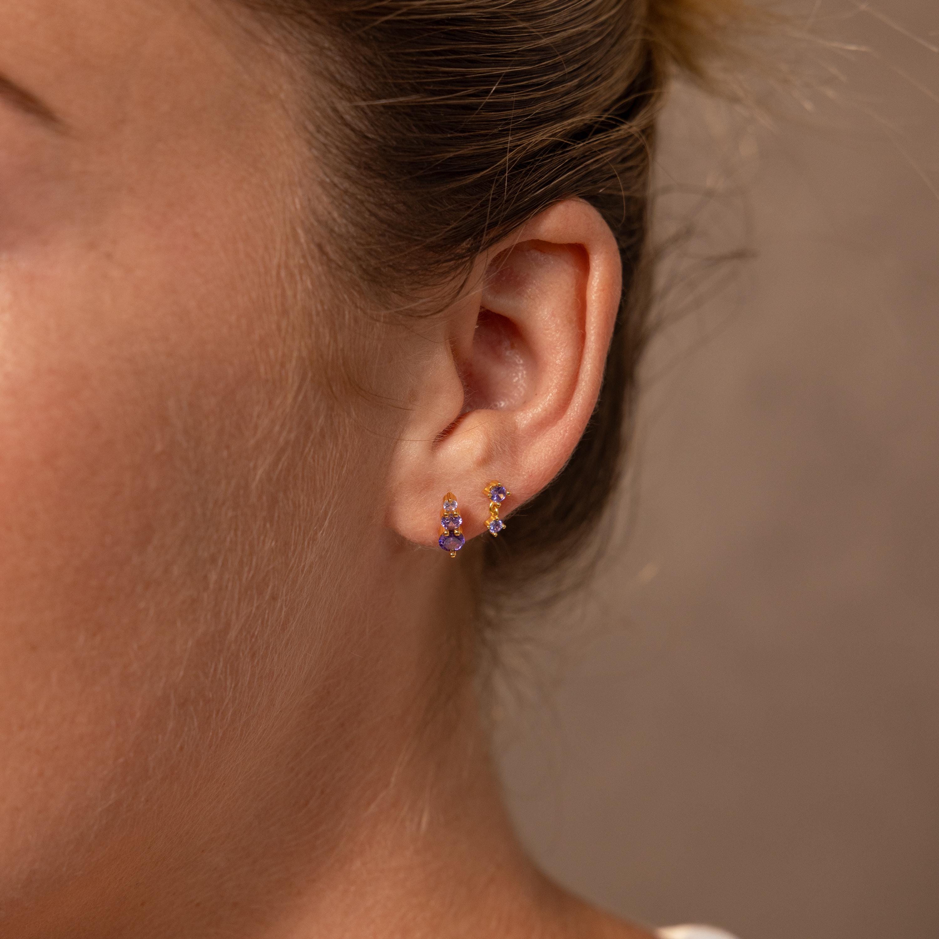 Close-up of a person’s ear wearing Ombre Topaz Flatback Studs—small, colorful topaz earrings, perfect for adding a personalized touch or giving as a unique gift.