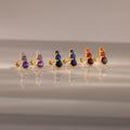 The Ombre Birthstone Flatback Studs feature three gold pairs with purple, blue, and orange gemstones—perfect for a personalized gift.
